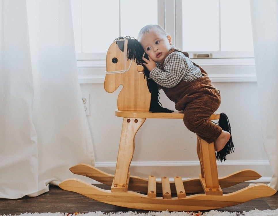Baby sitting on toy horse