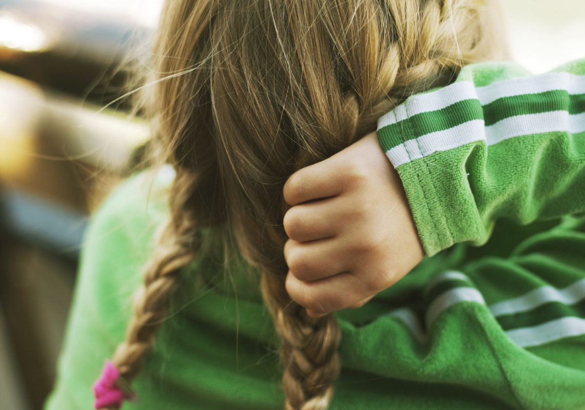 Rear view of girl holding her braid