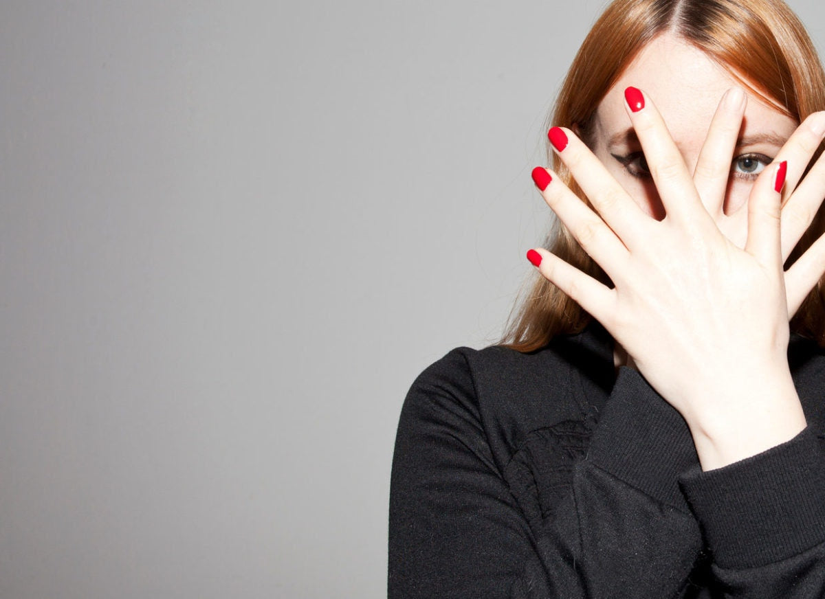 Woman Covering Her Face With Her Hands crossed And Peeking
