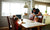 three little children sitting at dinning table and having a snack of biscuit