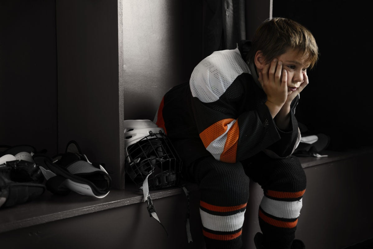 A child sitting in dressing room for a sports event
