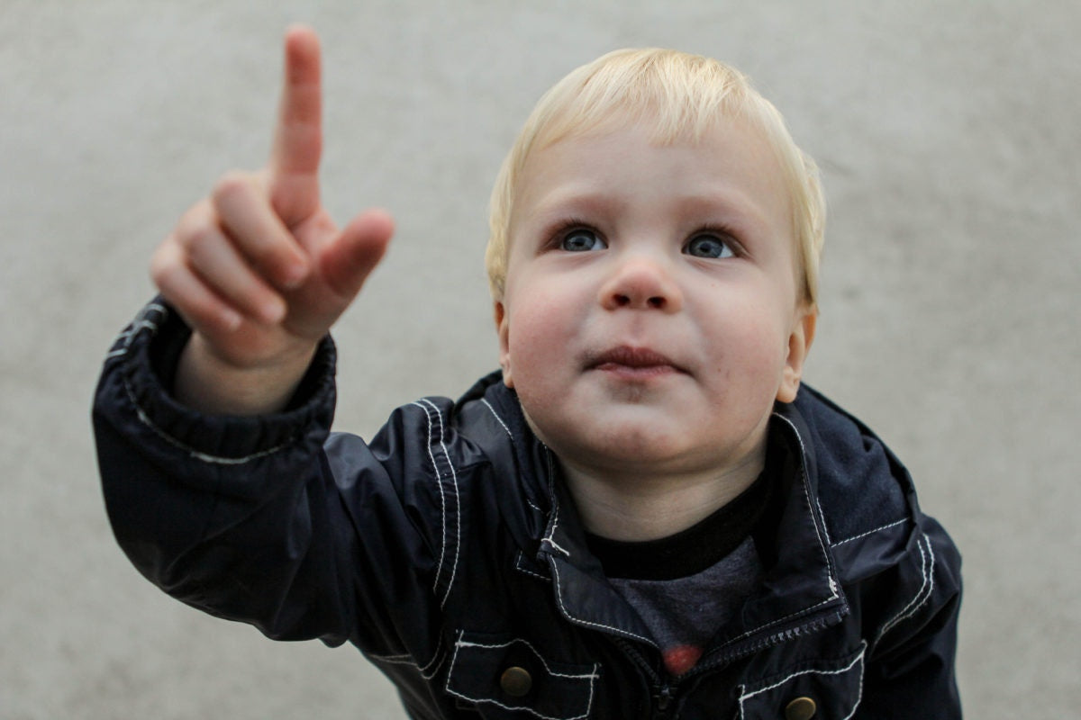 little boy looking up and pointing finger up