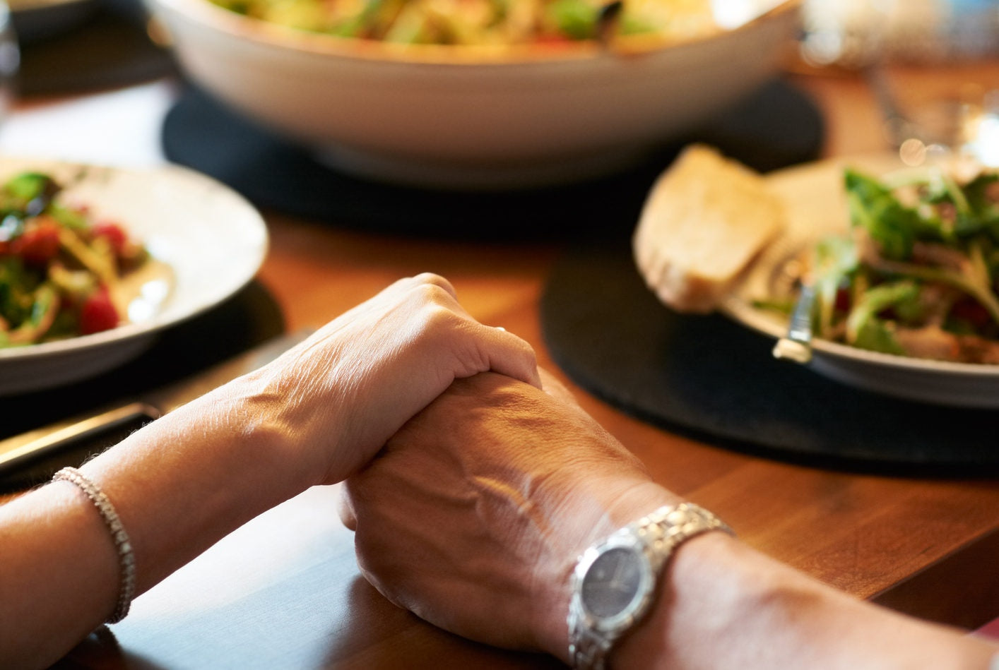 couple holding hands on restaurant table