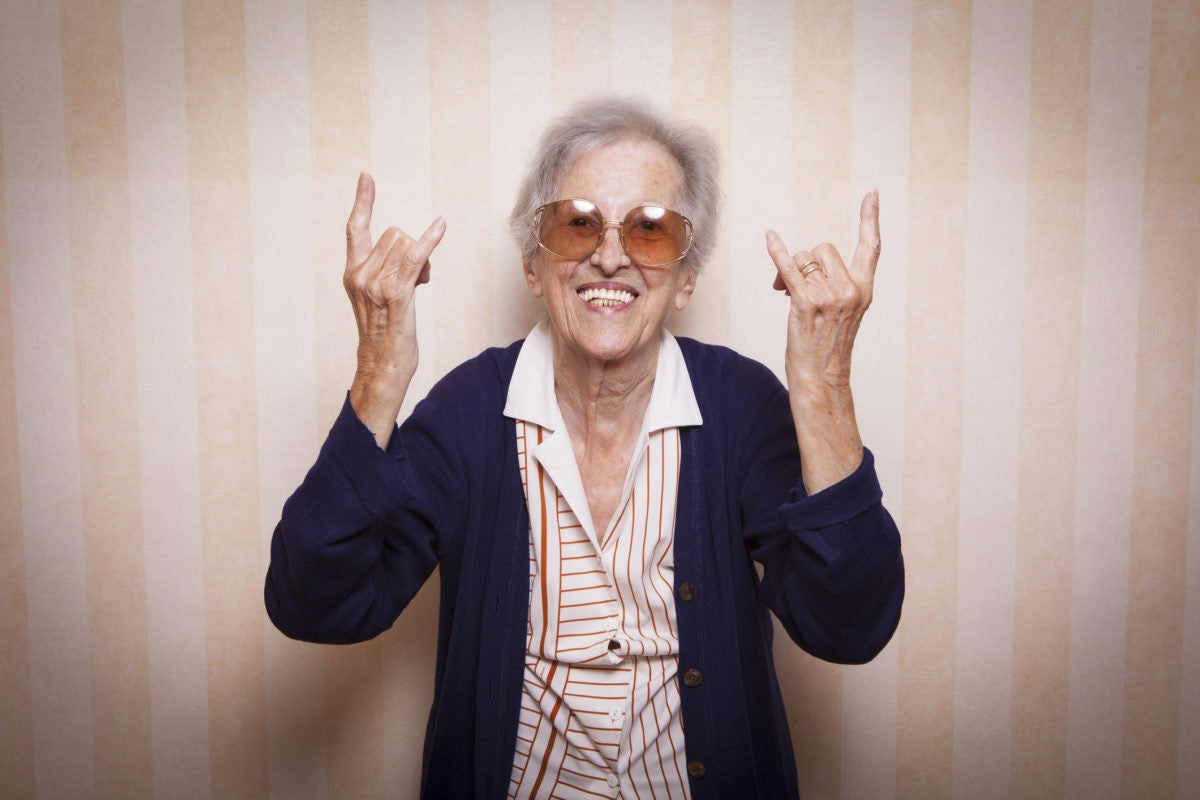 elderly woman show sign of the horns with her hands