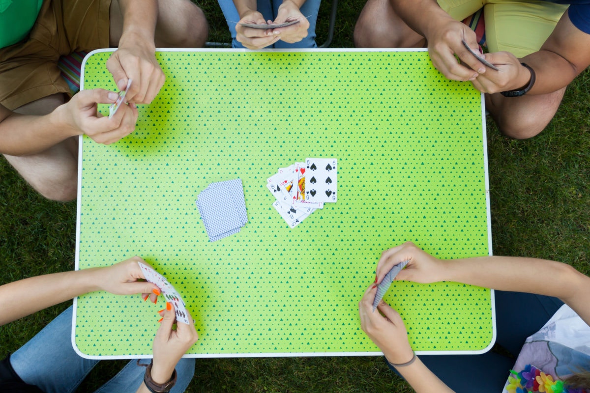 group of friends playing cards in garden
