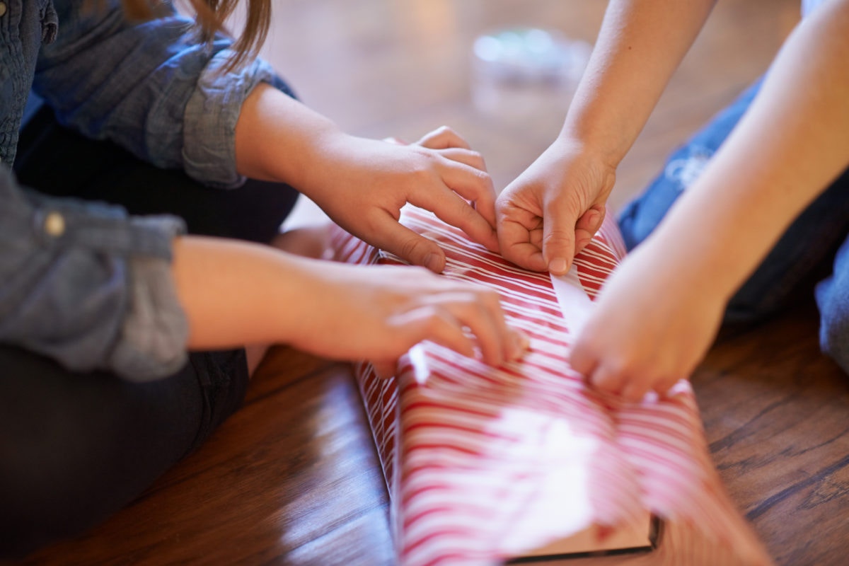 young children wrapping presents