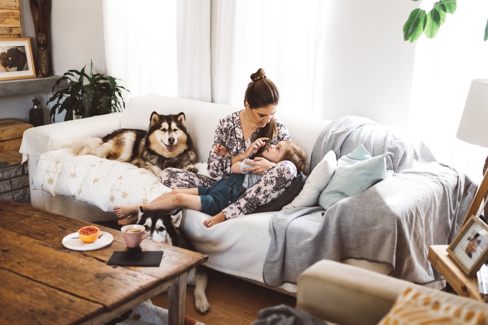 woman with child and dog on a couch