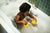 boy playing with rubber duckies in bathtub