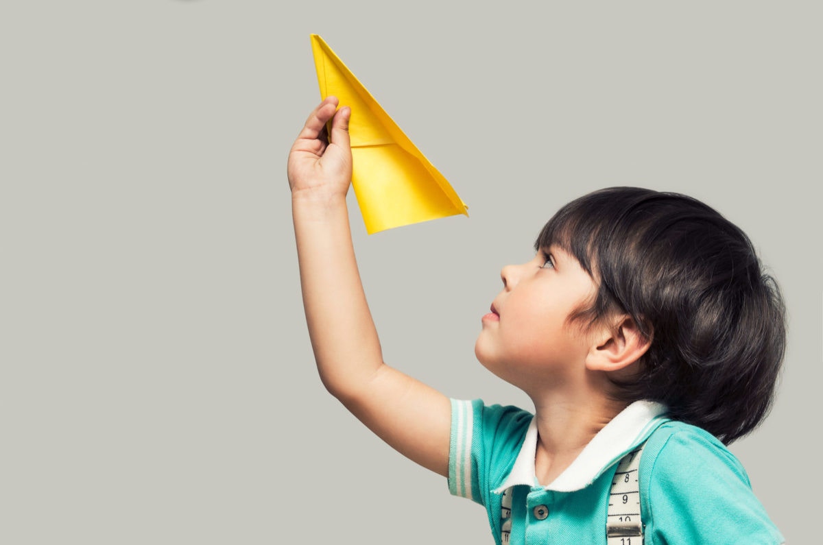 kid holding a paper plane
