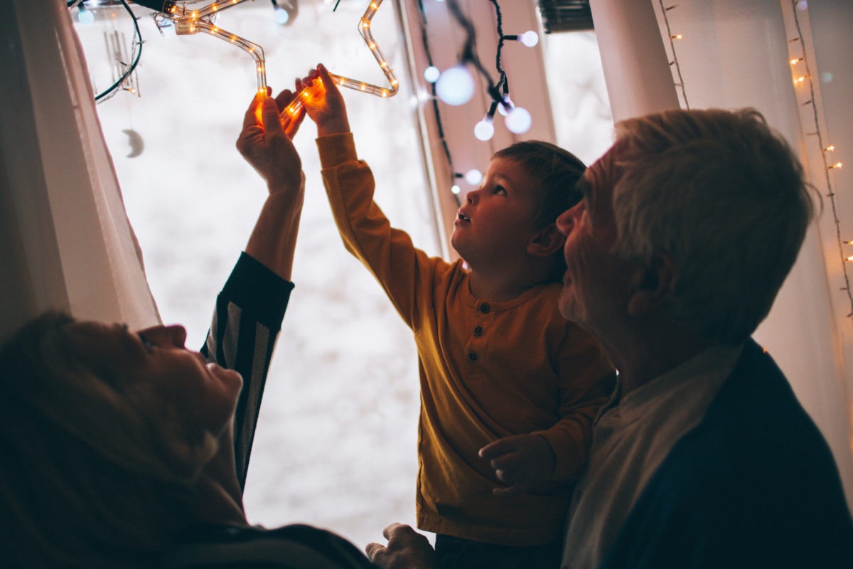 Child is playing with grandparents with christmas star