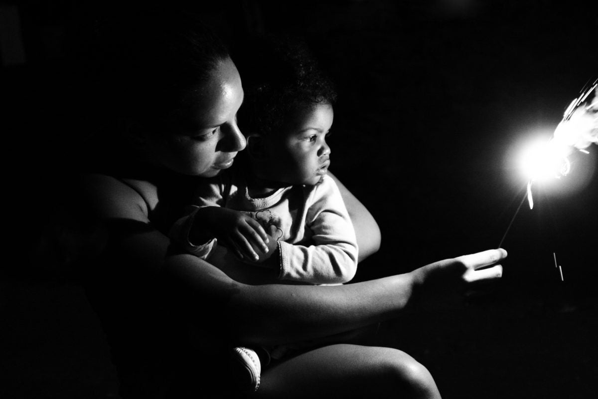 A mother is showing candlelight to her baby