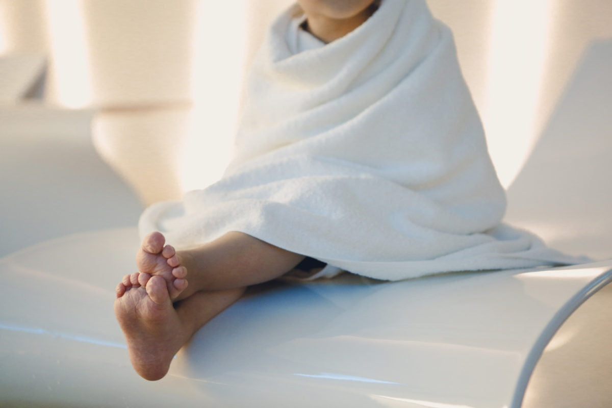 Child wrapped with white towel or blanket