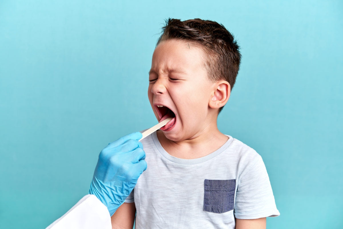 Doctor testing tongue of a kid
