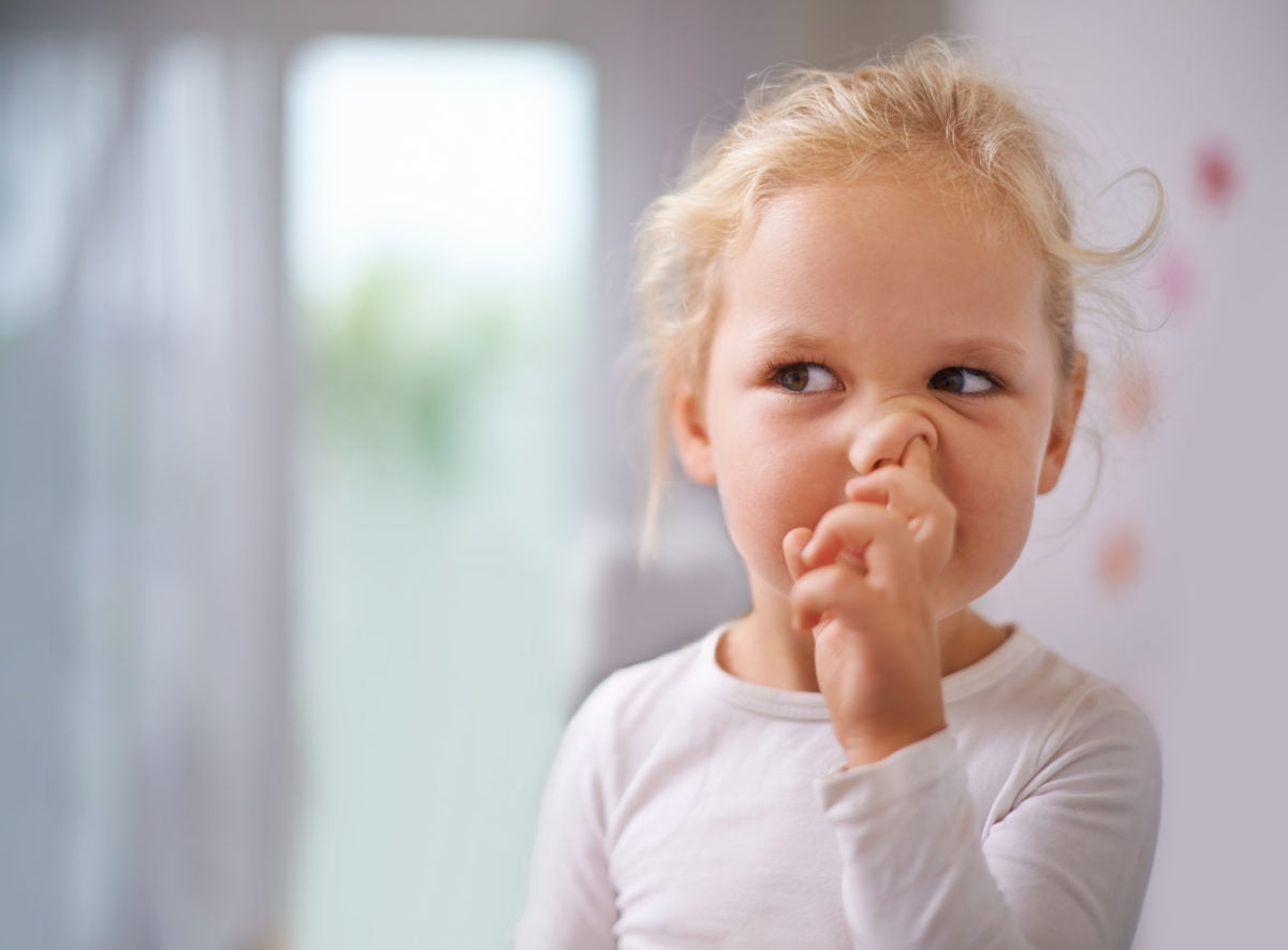 A kid putting finger on her nose
