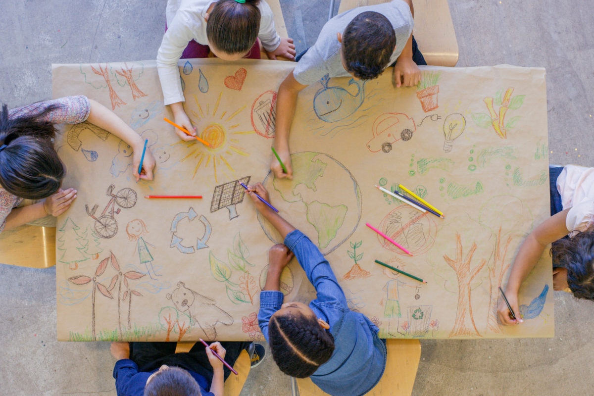 Children drawing on a table with color pencils
