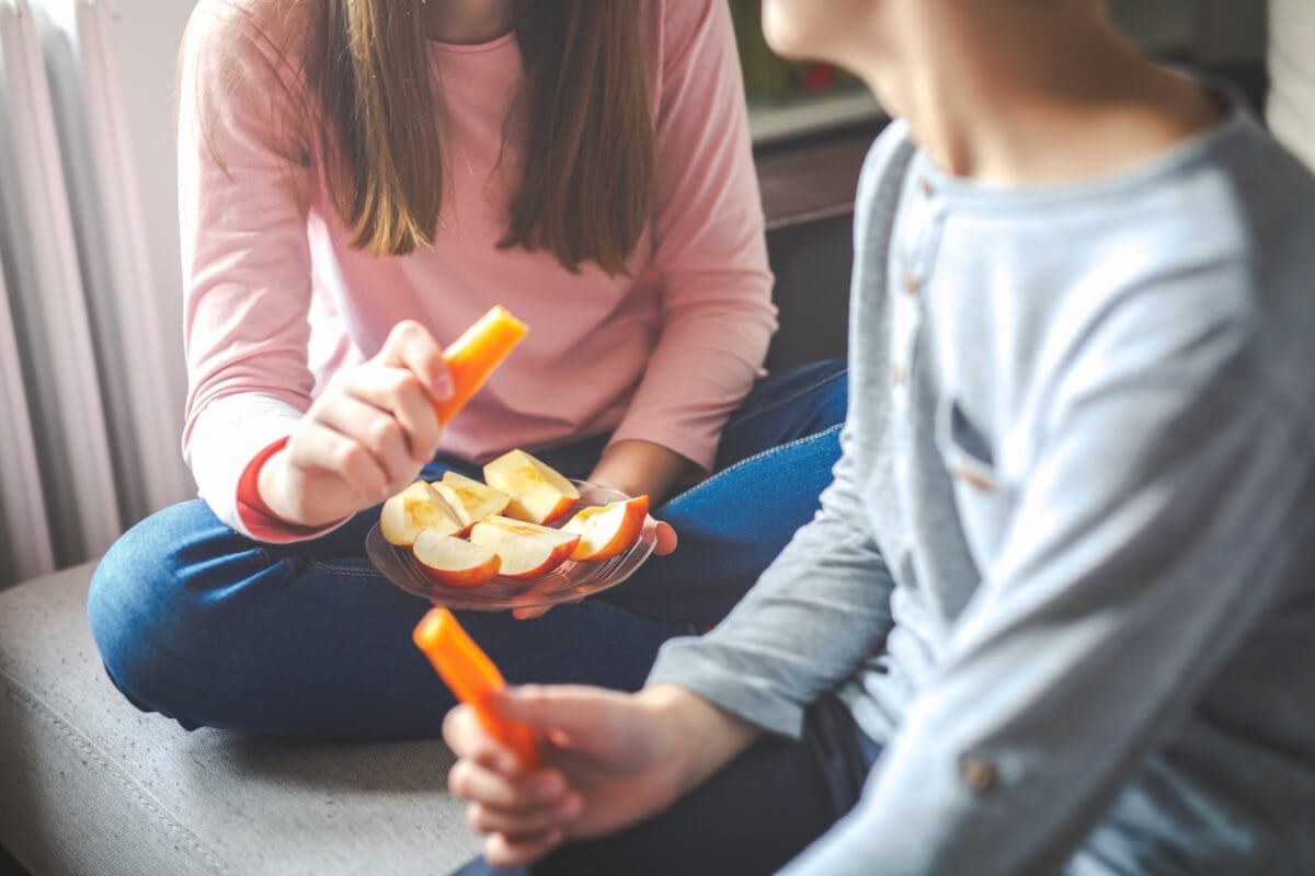 Two friends eating apple
