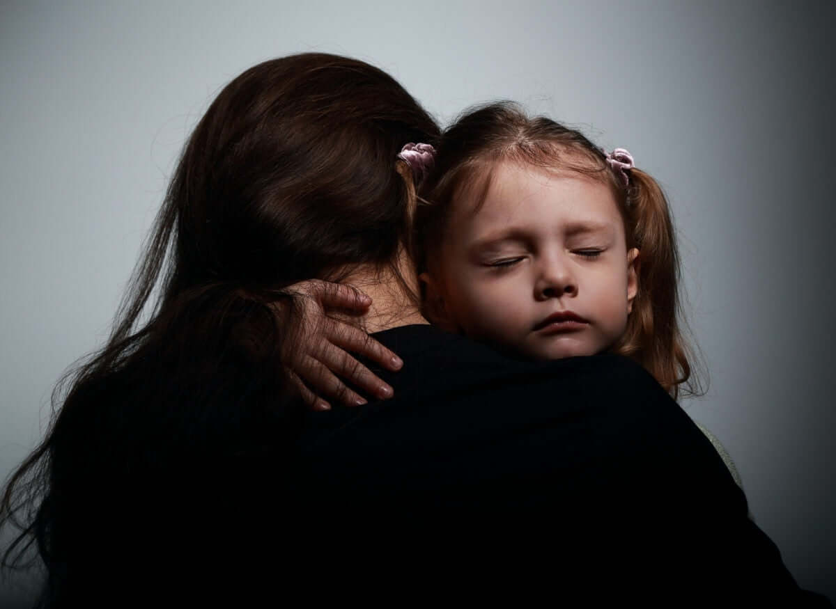 Close up face of little baby girl gives big hug to her mother and closing eyes for pleasure