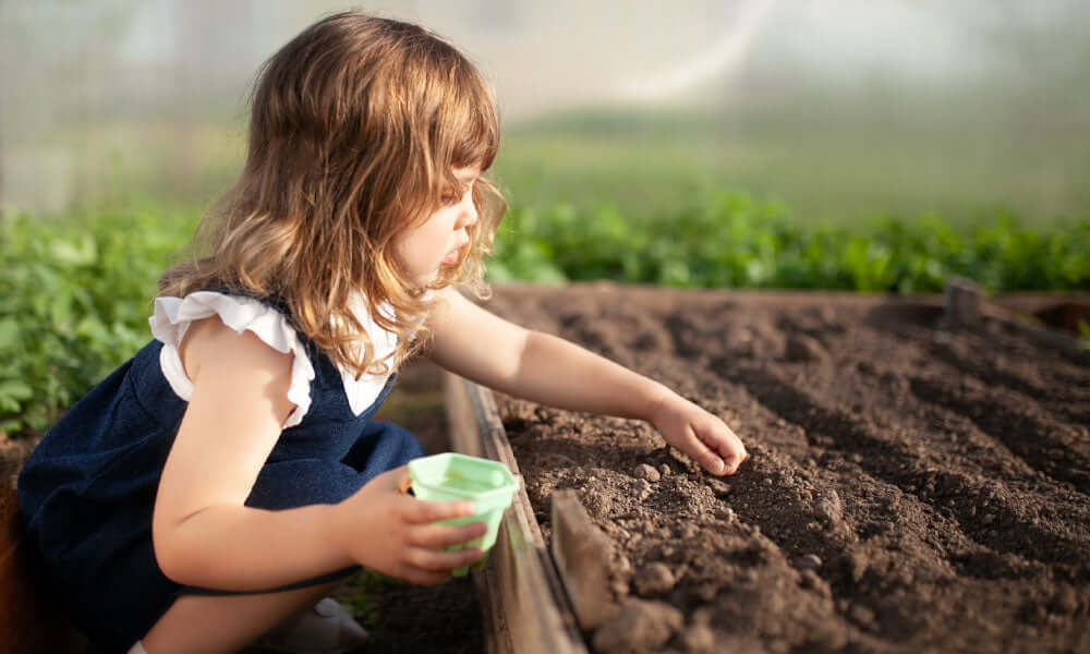 girl planting seeds in the ground
