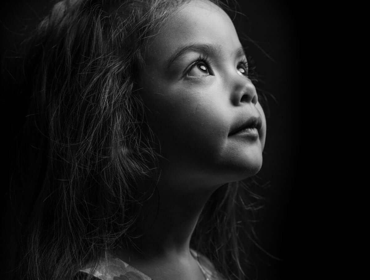 A kid is looking at a dark light