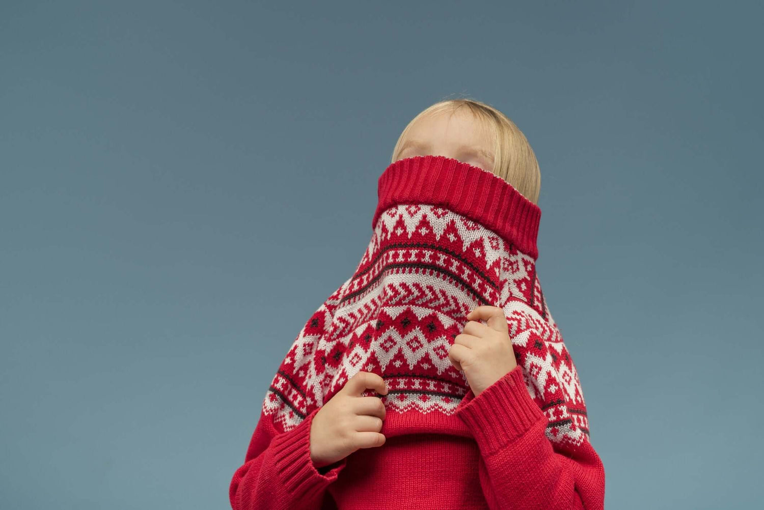 girl covers her face with red sweater