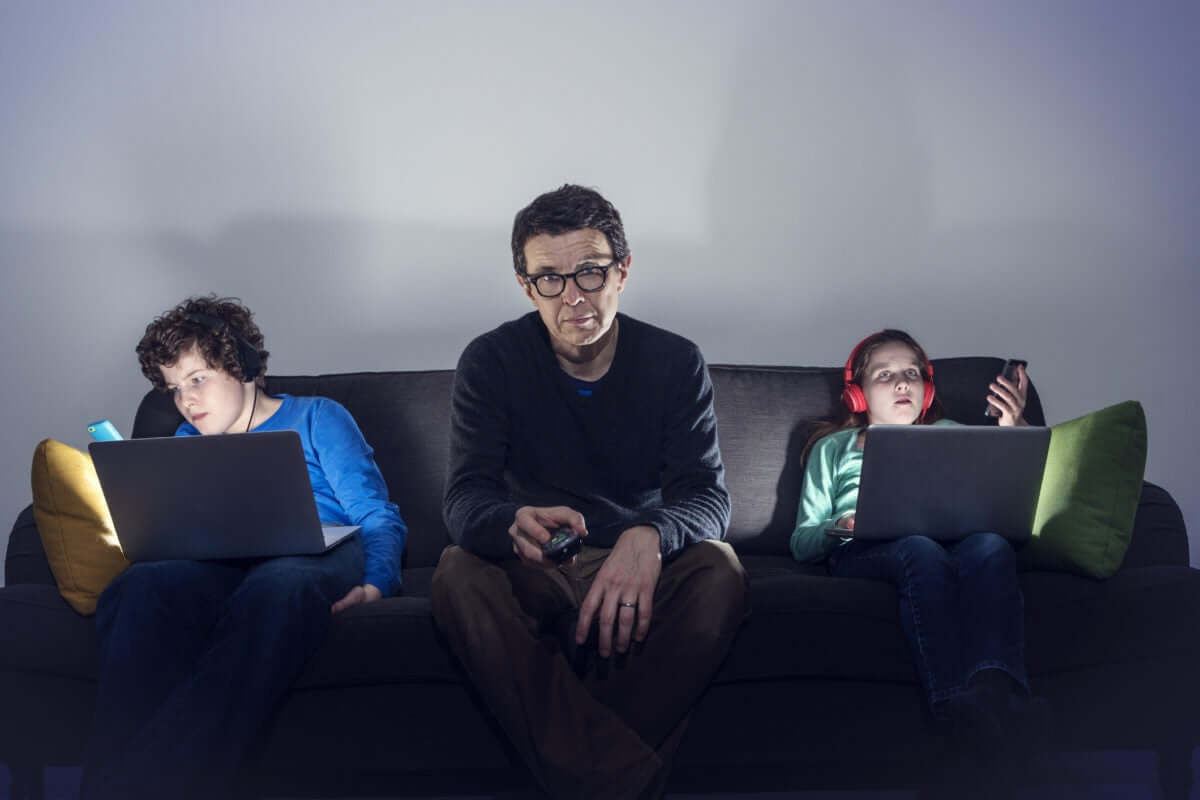 Childrens using laptop and father is watching