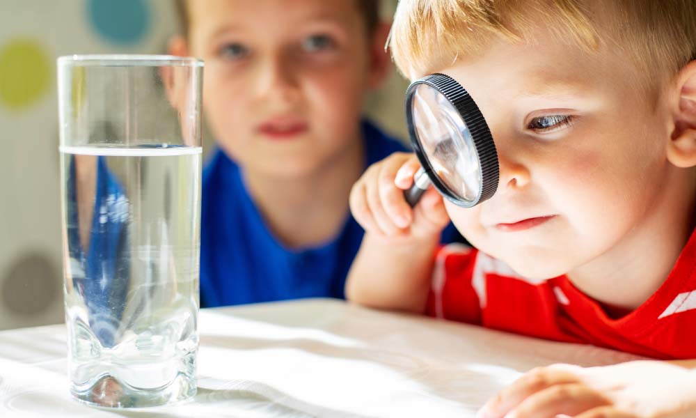 child boy looking at water in a glass