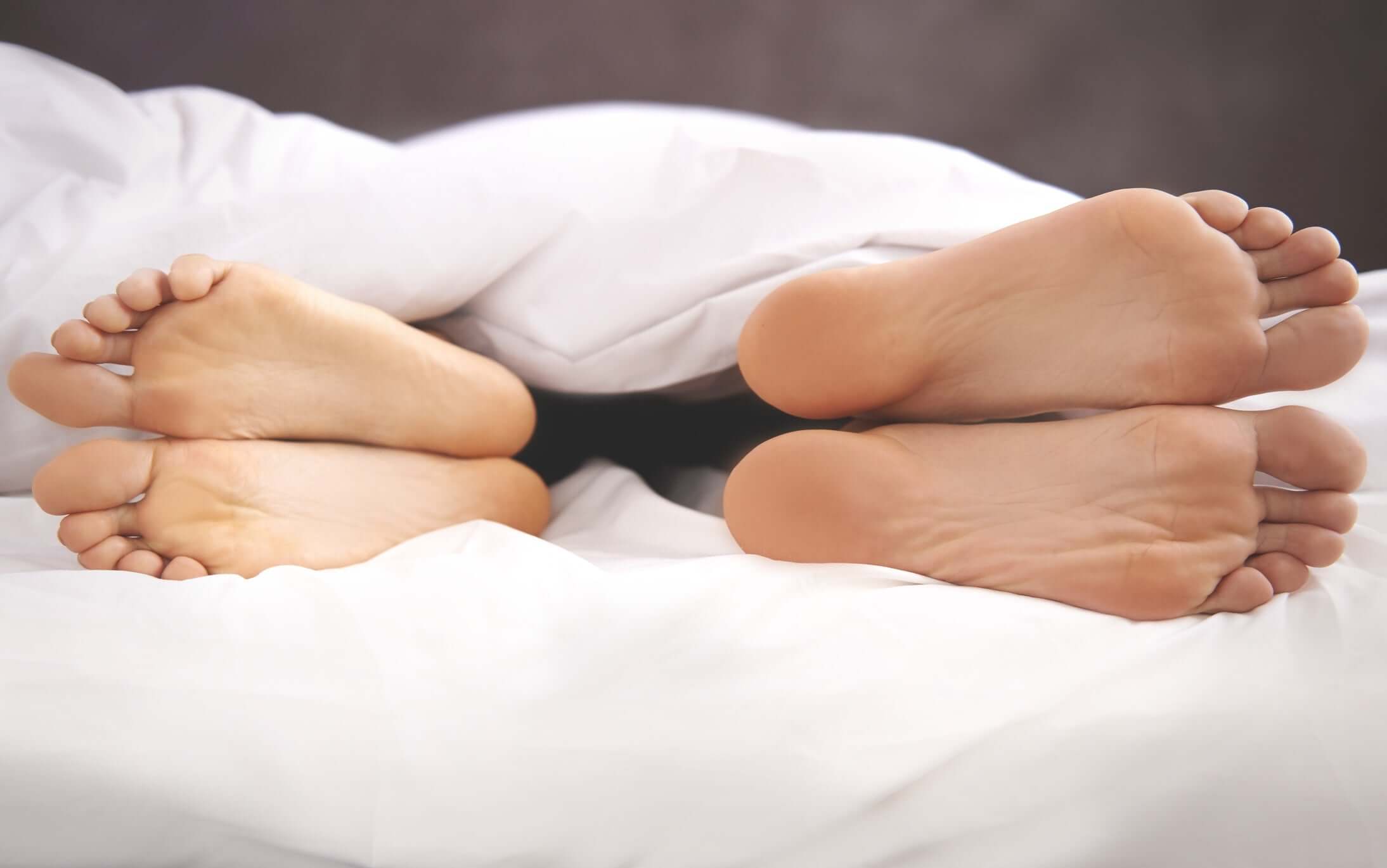 Mother and father  feet under blanket. 
