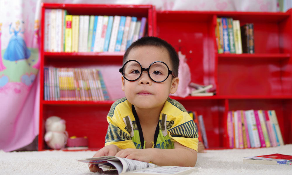 kid in glasses reading book