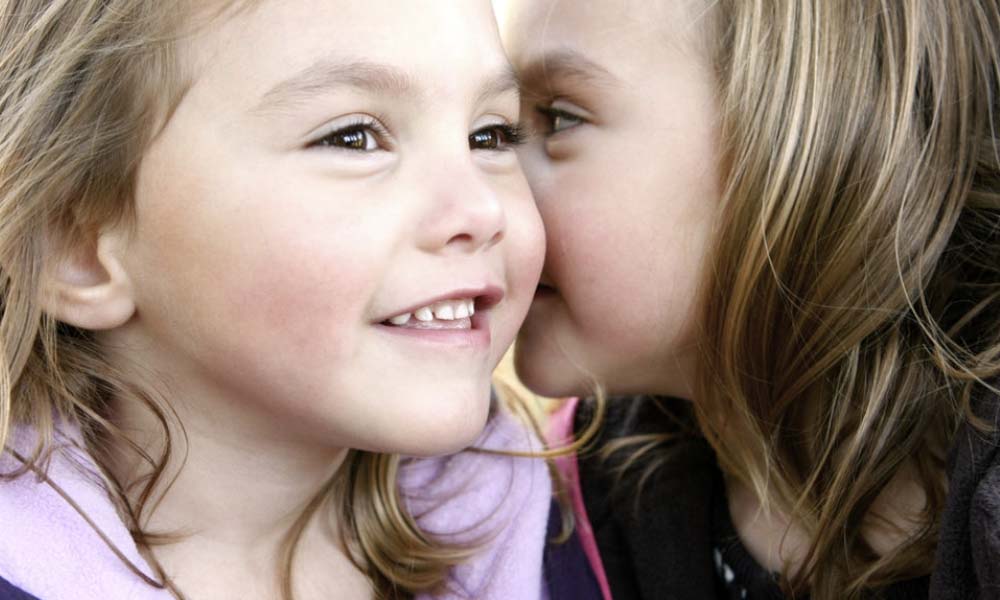 little girl kissing her sister