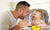 toddler eating food with father