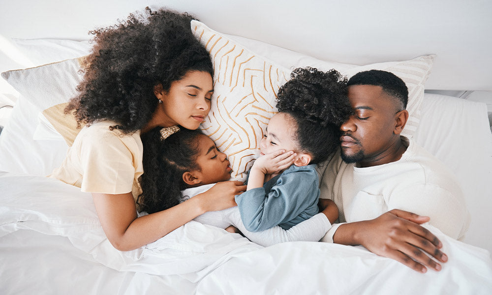 mom dad and kids in bed sleeping