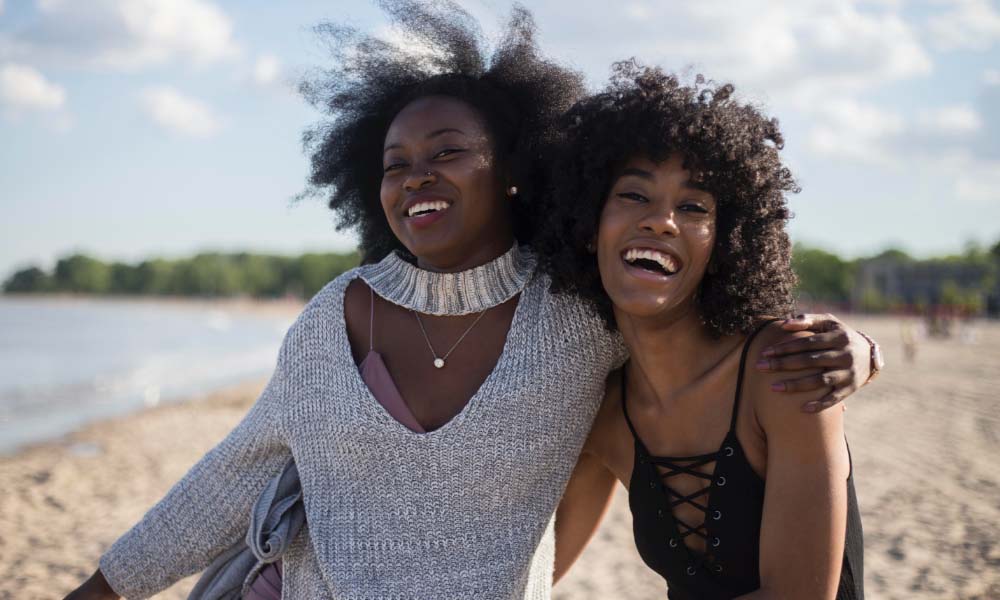 two women smiling on the beach